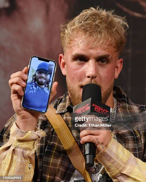 Jake Paul talks to mixed martial artist Jorge Masvidal on his cell phone during a news conference for Triller Fight Club's inaugural 2021 boxing...
