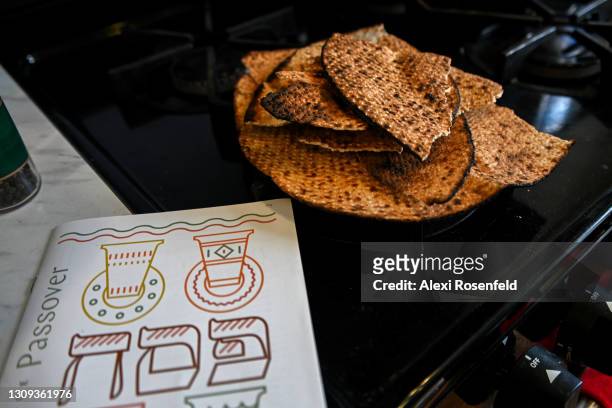 In this photo illustration, shmurah matzah sits on a stove near a Passover Hagada in Williamsburg on March 26, 2021 in the Brooklyn borough of New...