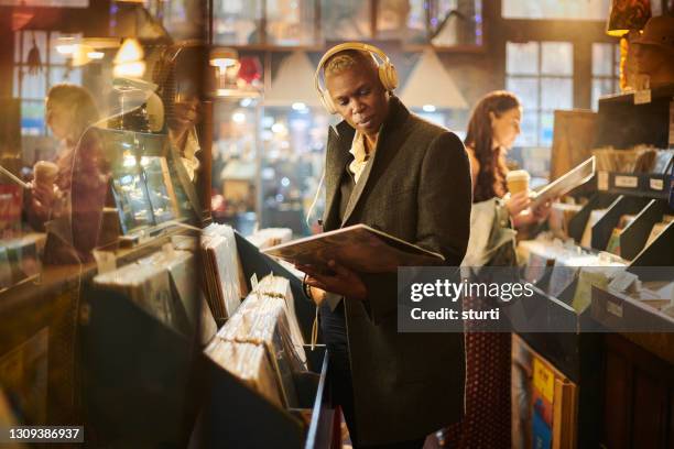 browsing records in a vintage shop - record shop stock pictures, royalty-free photos & images