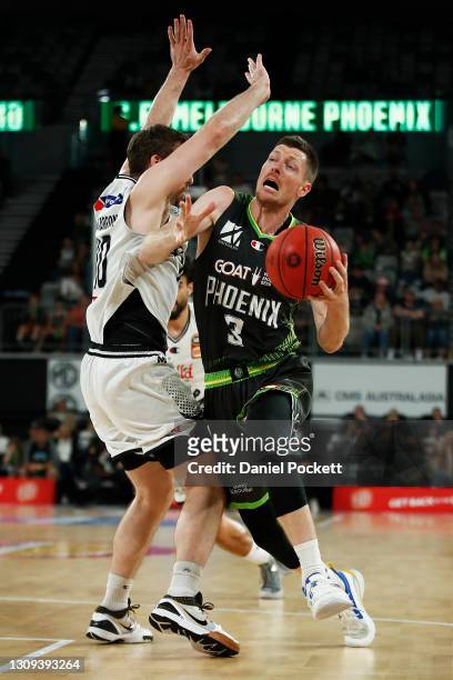 Cameron Gliddon of the Phoenix drives to the basket under pressure from Mitch McCarron of United during the round 11 NBL match between Melbourne...