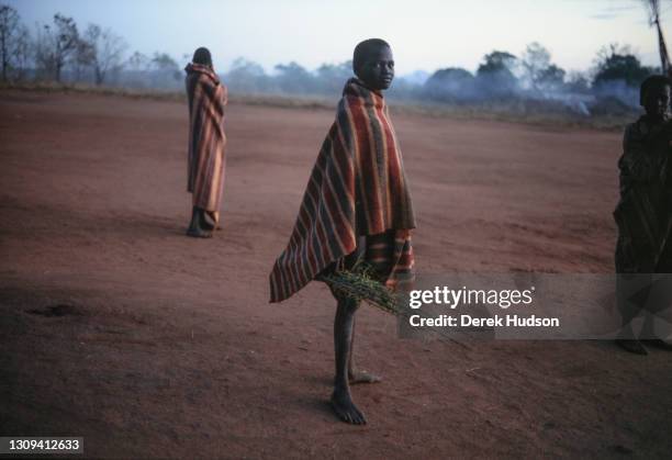 Sudanese refugee boy pictured wearing a blanket poses for a portrait at an abandoned mission near Palotaka, South Sudan, two hundred kilometres west...