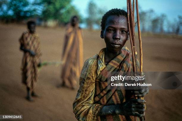 Sudanese refugee boy pictured holding stripped branches of wood at an abandoned mission near Palotaka, South Sudan, two hundred kilometres west of...