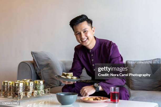 malaysian man with malay attire during hari raya celebration - hari raya celebration stock-fotos und bilder