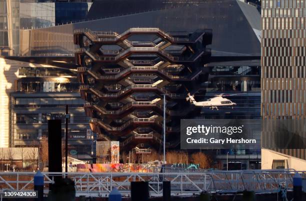 Helicopter flies past the Vessel at Hudson Yards as it lands at the 30th Street heliport in New York City on March 26, 2021 as seen from Weehawken,...