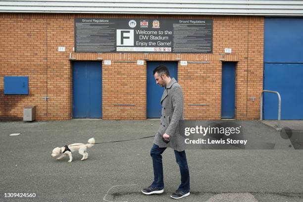 General view outside the stadium as a man walks his dog past closed turnstiles prior to the Sky Bet League One match between Wigan Athletic and...