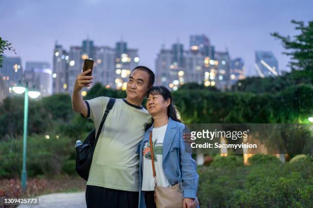 senior couple travelling in public park at night - older couple travelling photos et images de collection