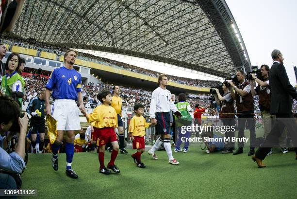 David Beckham of England and Johan Mjallby of Sweden lead there teams out before the World Cup 1st round match between Sweden and England at the...