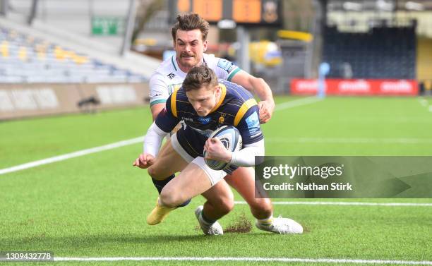 Chris Ashton of Worcester Warriors runs past George Furbank of Northampton Saints and scores their first try during the Gallagher Premiership Rugby...