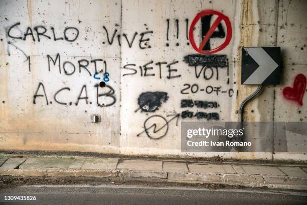 The writings Carlo vive i morti siete voi and ACAB with the date of Carlo Giuliani's death on a wall of an underpass on 20 July 2001, on March 27,...