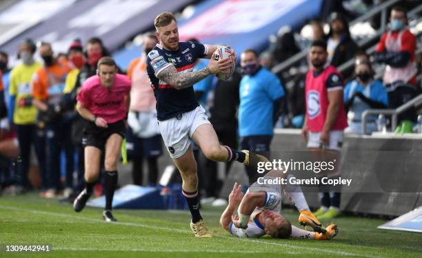 Tom Johnstone of Wakefield escapes the tackle of Brad Dwyer of Leeds during the Betfred Super League match between Wakefield Trinity and Leeds Rhinos...