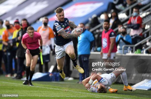 Tom Johnstone of Wakefield escapes the tackle of Brad Dwyer of Leeds during the Betfred Super League match between Wakefield Trinity and Leeds Rhinos...