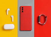 Smartphone, white wireless earphones and smart watch