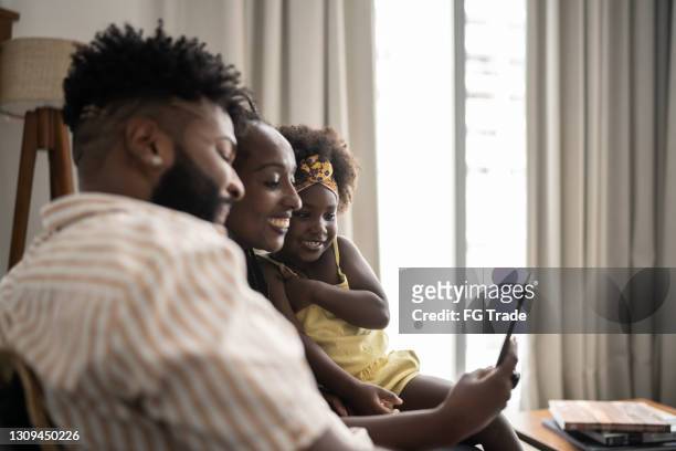 family doing a video call on smartphone at home - mother media call stock pictures, royalty-free photos & images