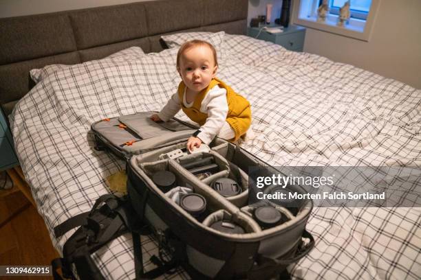 baby checking the camera accessories - camera bag stock-fotos und bilder