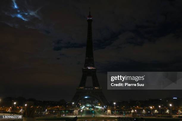 The Eiffel Tower submerges into darkness as part of the Earth Hour switch-off on March 27, 2021 in Paris, France. On the initiative of the World Wide...