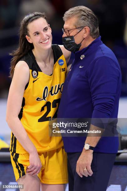 Head coach Geno Auriemma of the UConn Huskies speaks with Caitlin Clark of the Iowa Hawkeyes following their 92-72 win in the Sweet Sixteen round of...