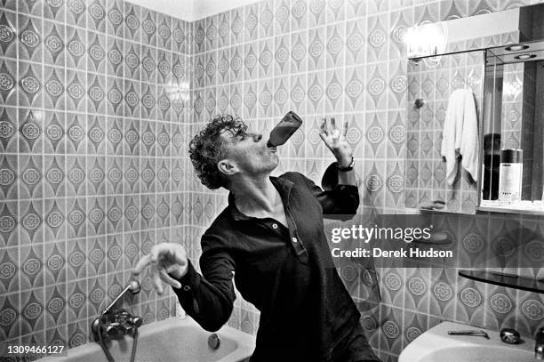 Australian cinematographer Christopher Doyle fooling around in the bathroom of his hotel in Cannes as he demonstrates how he drinks a bottle of beer...