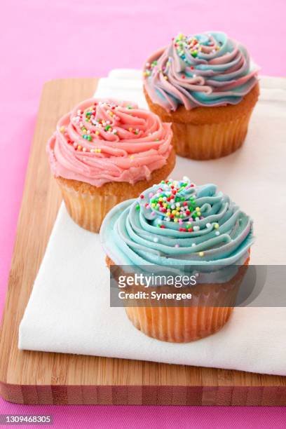 rosa und blaue cupcakes mit streuseln - cupcake stock-fotos und bilder