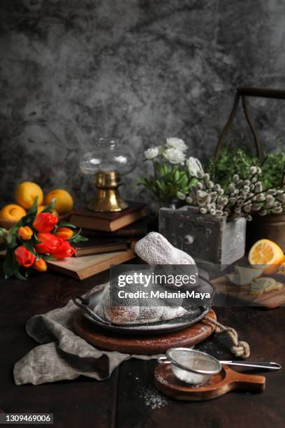 de cake van de paashaas met tulpen in donkere rustieke keuken - paastafel stockfoto's en -beelden