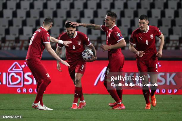 Aleksandar Mitrovic of Serbia celebrates with Sergej Milinkovic­-Savic and Stefan Mitrovic after scoring their team's first goal during the FIFA...