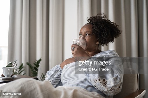 Mature woman using an inhalation mask at home Mature woman using an inhalation mask at home
