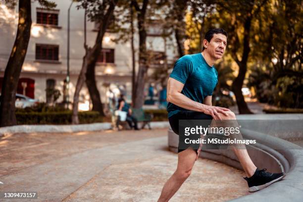 de atleet rekt zich uit voor de training - latina legs stockfoto's en -beelden