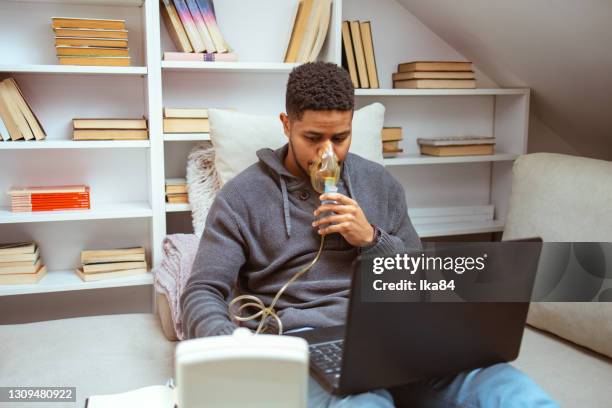 young man inhales at home - chronic condition stock pictures, royalty-free photos & images