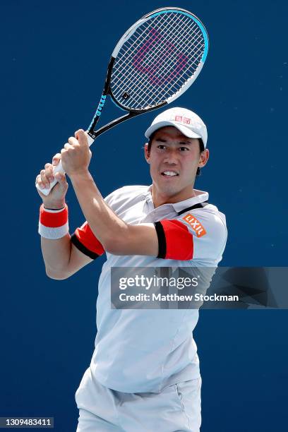 Kei Nishikori of Japan returns a shot to Aljaz Bedene of Slovenia during the Miami Open at Hard Rock Stadium on March 27, 2021 in Miami Gardens,...