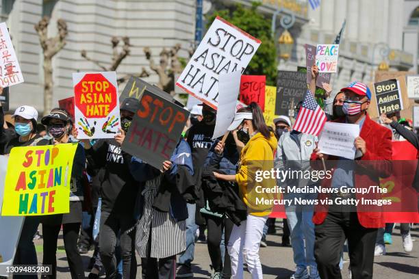 Demonstrators hold up signs as they take part in an anti-Asian American hate march and rally at San Francisco City Hall in San Francisco, Calif., on...