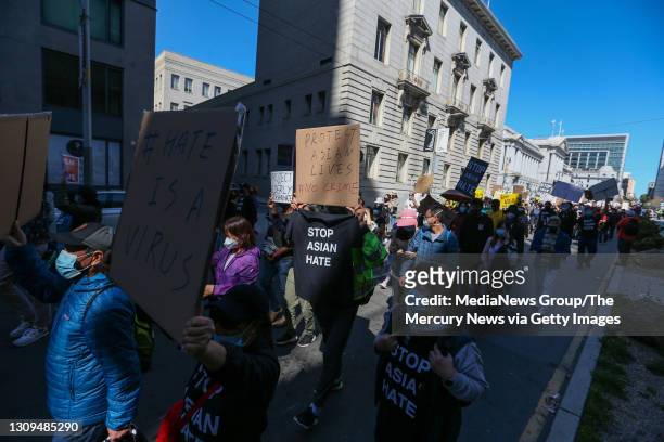 Demonstrators hold up signs as they take part in an anti-Asian American hate march and rally at San Francisco City Hall in San Francisco, Calif., on...