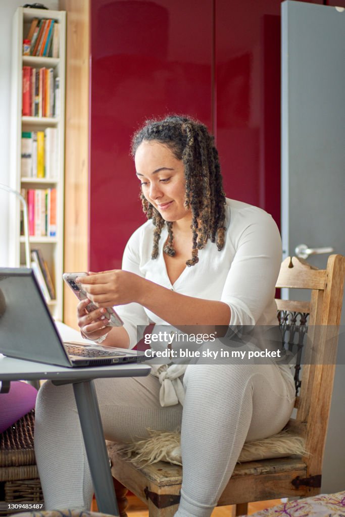 A young woman with her laptop at a desk in the bedroom