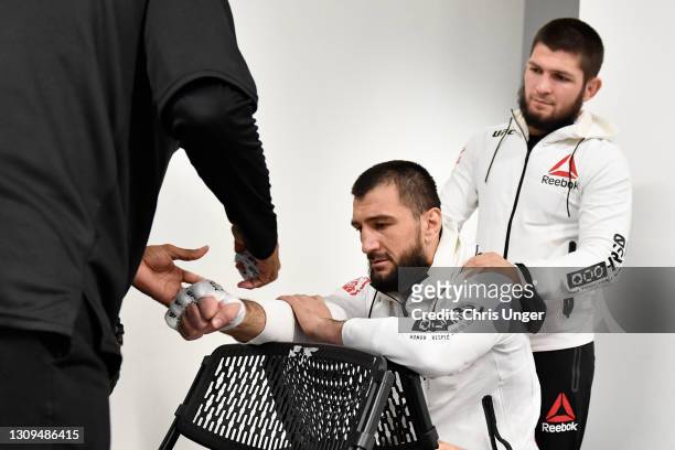 Abubakar Nurmagomedov of Russia has his hands wrapped prior to his fight as his cousin and former UFC lightweight champion Khabib Nurmagomedov looks...