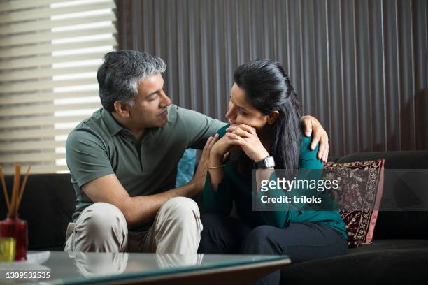 man comforting his wife at home - emotional support stock pictures, royalty-free photos & images