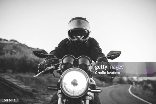 montando la clásica motocicleta por el campo. - vintage motorcycle fotografías e imágenes de stock