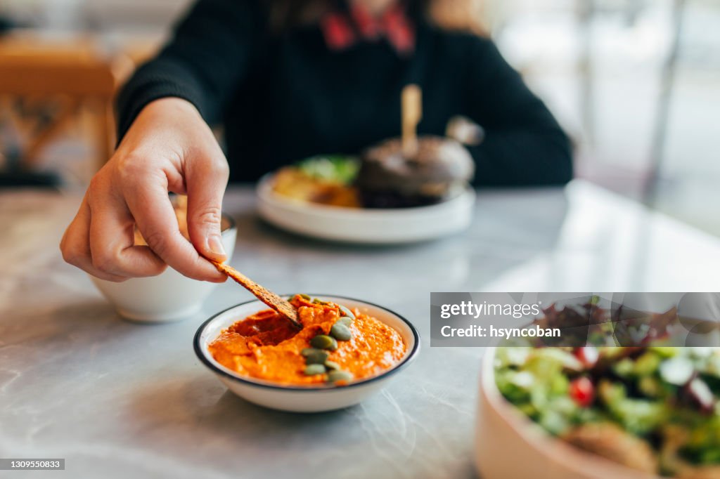 Frau isst Hummus in einem Restaurant