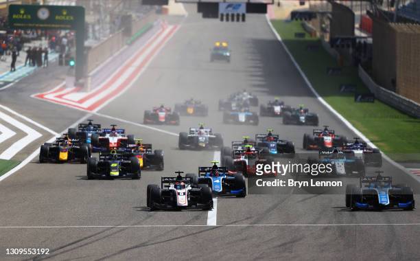 Christian Lundgaard of Denmark and ART Grand Prix and Guanyu Zhou of China and UNI-Virtuosi Racing battle for position into turn one at the start...
