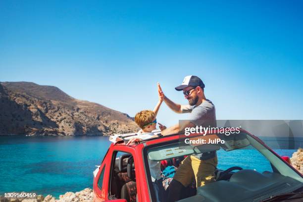 de zitting van de vader en van de zoon in de auto bij het strand - family holiday europe stockfoto's en -beelden