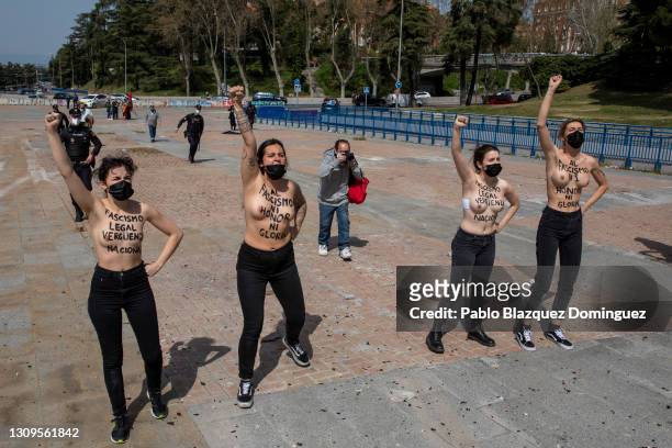 Activist with body paint reading 'To fascism neither honor, nor glory.' raise their fists during a gathering of right-wing supporters at Arco de la...