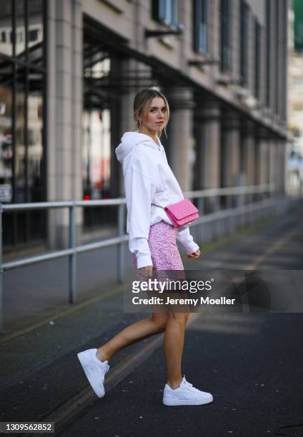 Scarlett Gartmann wearing white Weekday sweater, pink & other stories mini skirt, pink Chanel Wallet on Chain bag and Puma sneakers on March 24, 2021...