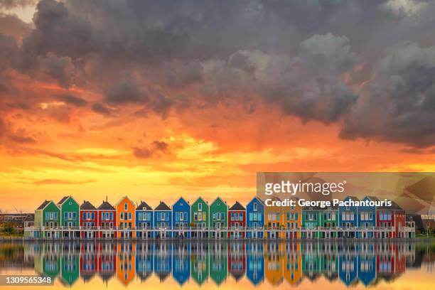 row of modern colorful houses reflection on a lake - utrecht stockfoto's en -beelden
