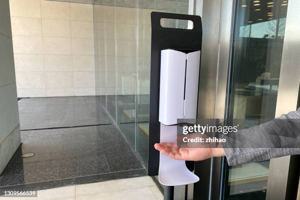 human hand using automatic hand sanitizer dispenser - soap dispenser stock pictures, royalty-free photos & images