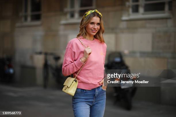 Scarlett Gartmann wearing pink Vogue sweater, Zara blue jeans, yellow H&M headband and yellow Chanel leather bag on March 24, 2021 in Dusseldorf,...