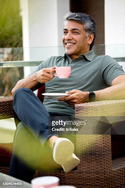 porträt des mannes, der auf sesseln sitzt - tee indien trinken stock-fotos und bilder