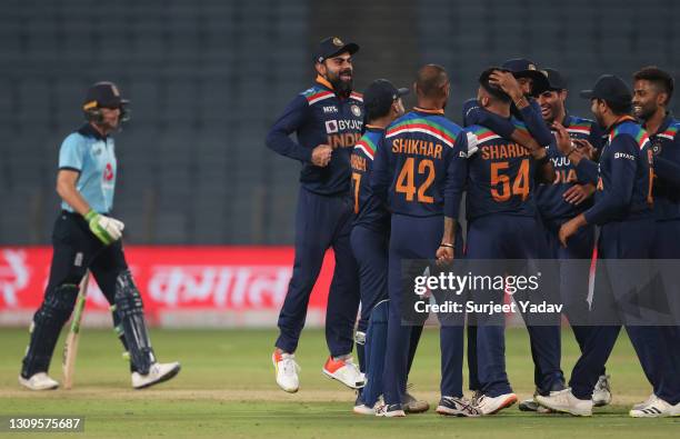 Players of India celebrate led by Virat Kohli as the wicket of Jos Buttler of England is given out on review during the 3rd One Day International...