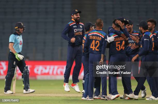 Players of India celebrate led by Virat Kohli as the wicket of Jos Buttler of England is given out on review during the 3rd One Day International...