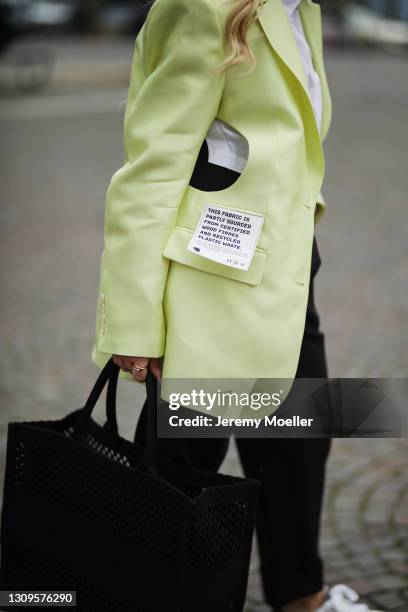 Martina Maturi wearing white H&M blouse, neon yellow H&M Studio blazer, black pants and black Dior tote bag on March 25, 2021 in Cologne, Germany.