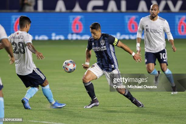 Javier Hernandez of Los Angeles Galaxy controls the ball against A.J. DeLaGarza of New England Revolution during the first half at Dignity Health...