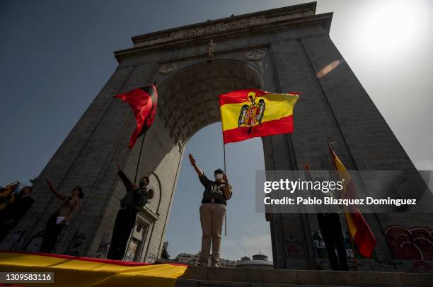 Franco supporters do the fascist salute as one holds a pre-constitutional Spanish flag during a gathering of right-wing supporters at Arco de la...