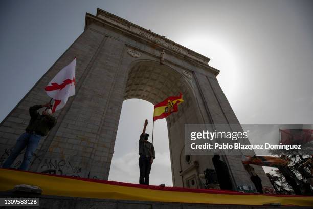 Franco supporters do the fascist salute as one holds a pre-constitutional Spanish flag during a gathering of right-wing supporters at Arco de la...