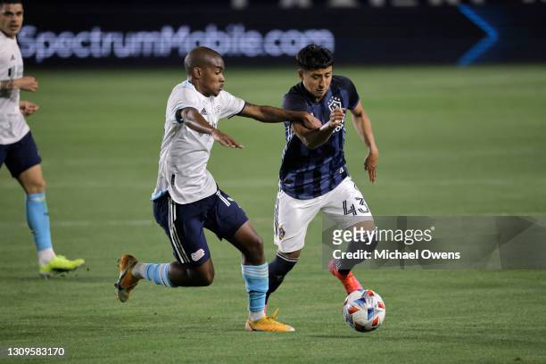 Lucas Maciel of New England Revolution and Adam Saldana of Los Angeles Galaxy battle for the ball during the first half at Dignity Health Sports Park...
